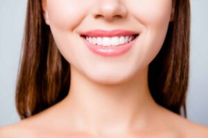 Close-up of a woman smiling and showing straight teeth