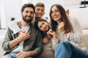 Smiling family with two children sitting together on a couch